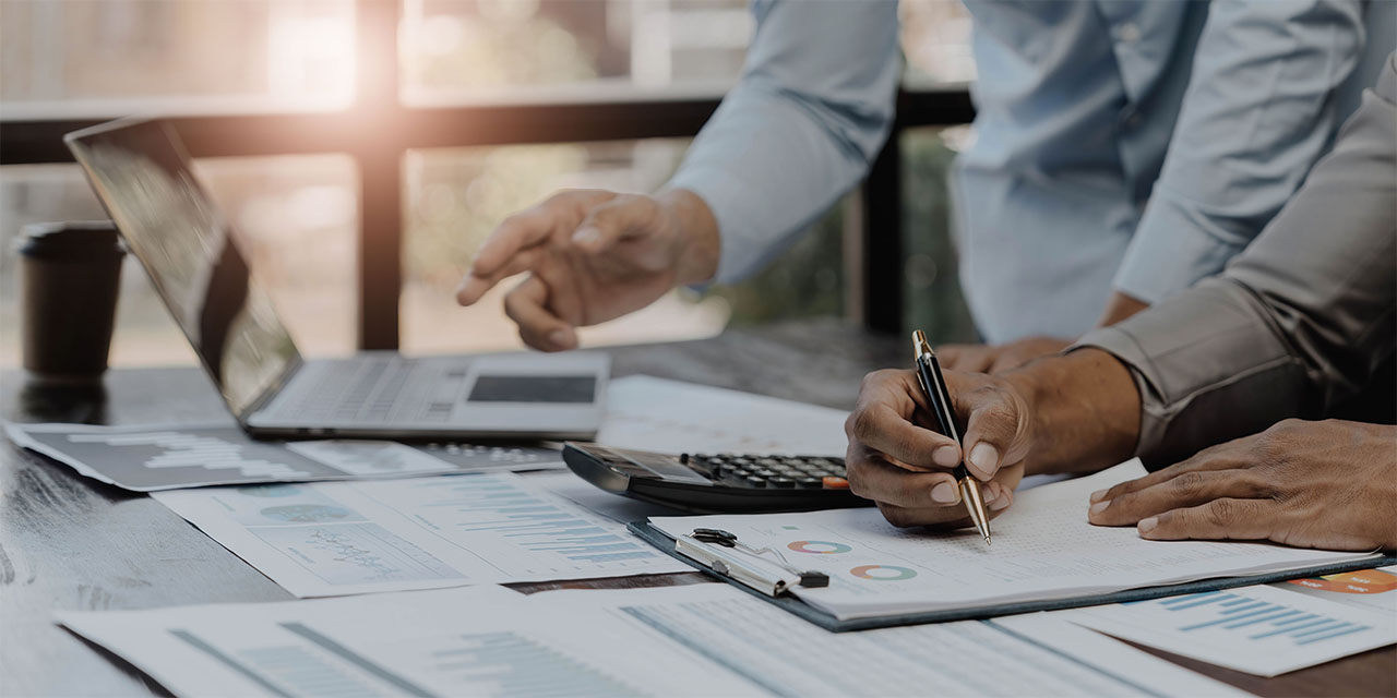 business people meeting using laptop computer,calculator,notebook,stock market chart paper for analysis plans to improve quality next month. conference discussion corporate concept.